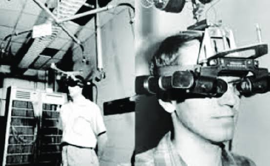Black-and-white photograph of Ivan Sutherland's 1968 Sword of Damocles head-mounted display in a lab.